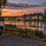 Visiter tours en camping car : camping-car sur une aire près de la Loire, au crépuscule